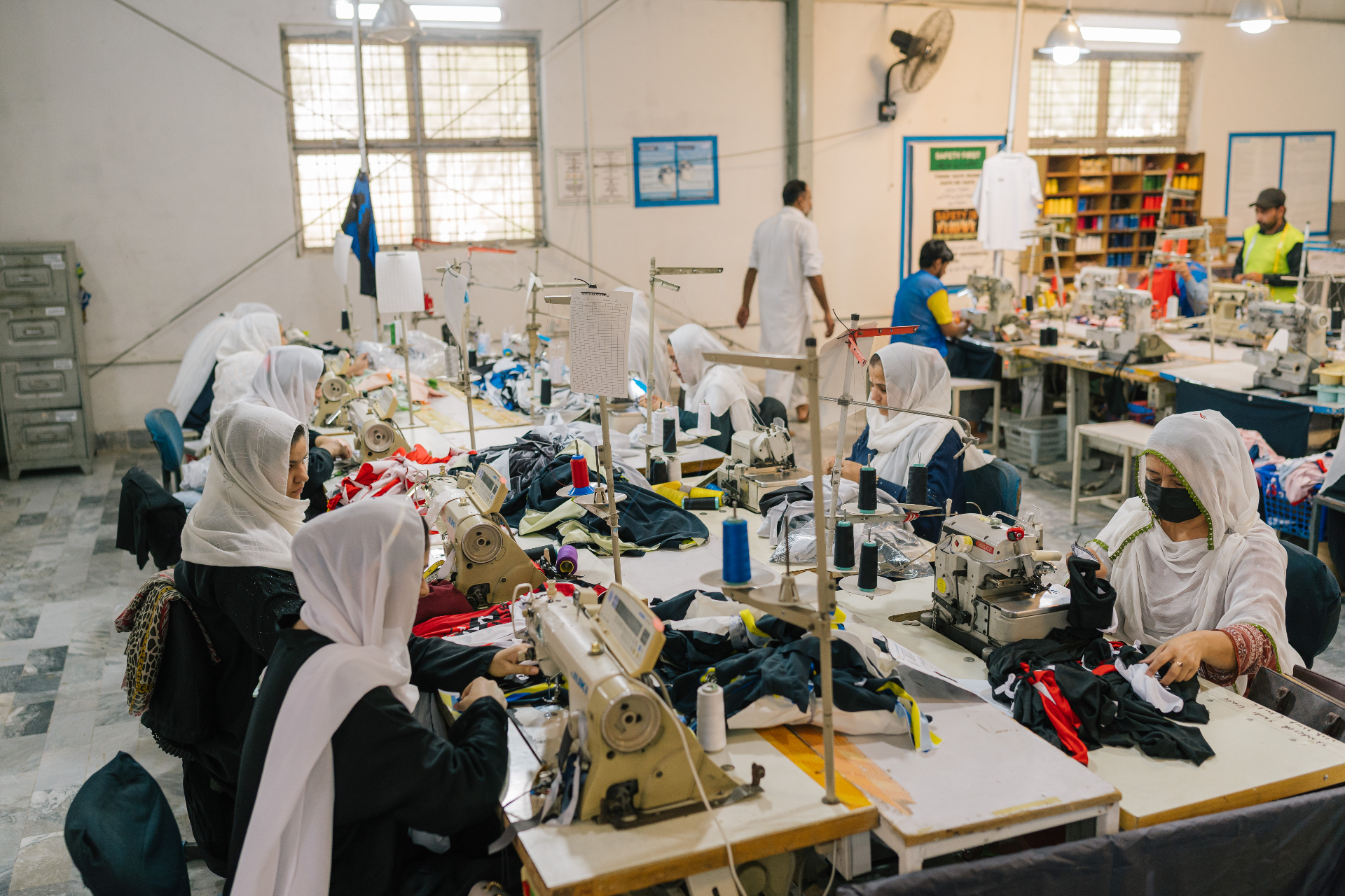 Tailors stitching sublimated team kits at an audited Sialkot facility